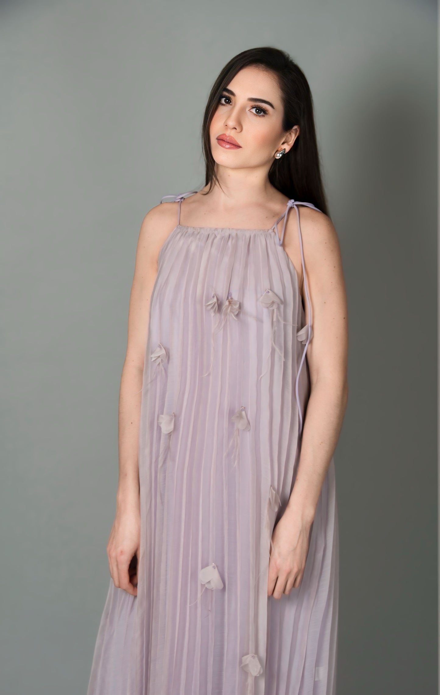 Vestido plissado decorado com flores e penas